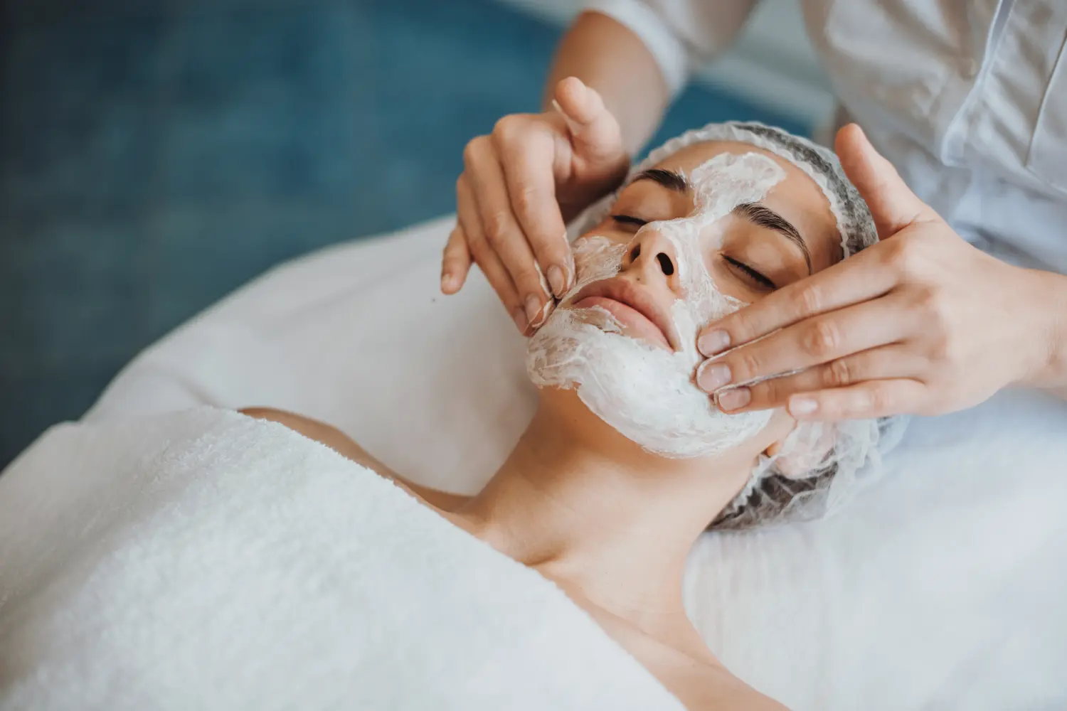 Nahaufnahme der Anwendung einer anorganischen Gesichtsmaske im Spa-Salon
