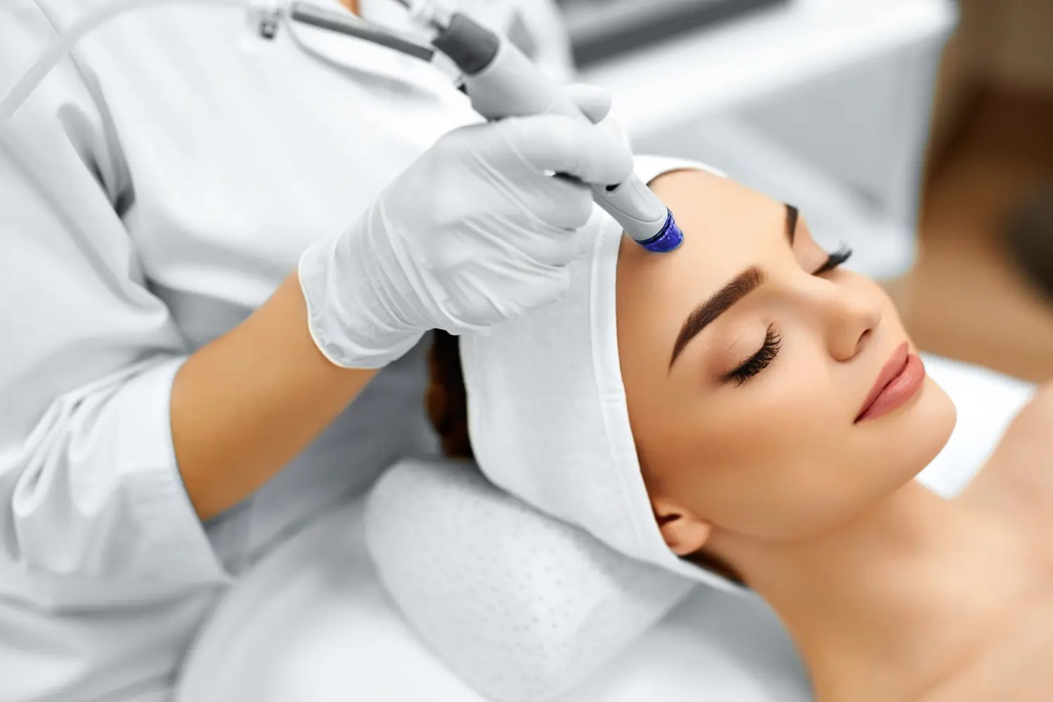 Nahaufnahme einer Frau, die in der Cosmetic Beauty Spa Clinic eine Hydro-Mikrodermabrasion-Peeling-Behandlung für das Gesicht erhält